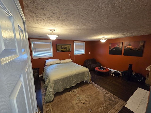 bedroom with hardwood / wood-style flooring and a textured ceiling