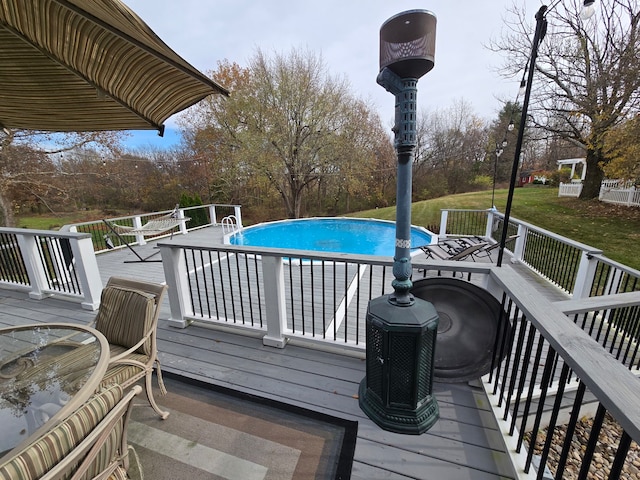 view of swimming pool featuring a lawn and a wooden deck