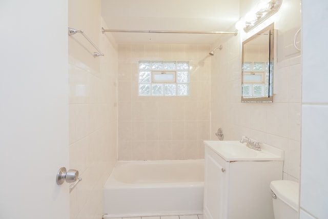 full bathroom with a wealth of natural light, tiled shower / bath combo, tile walls, and toilet