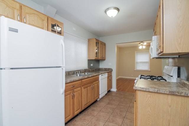 kitchen featuring light tile patterned flooring, white appliances, and sink