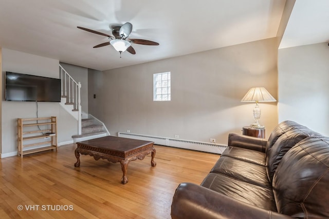 living room featuring hardwood / wood-style flooring, ceiling fan, and a baseboard heating unit