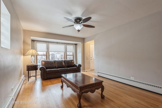 living room with ceiling fan, light wood-type flooring, and baseboard heating