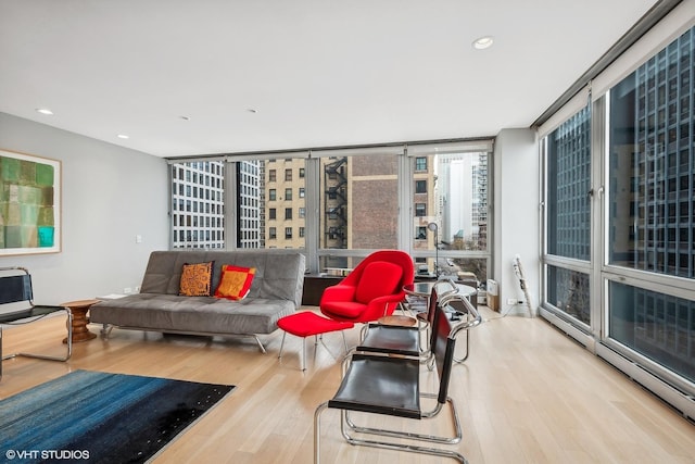 living room with light hardwood / wood-style flooring and a wall of windows