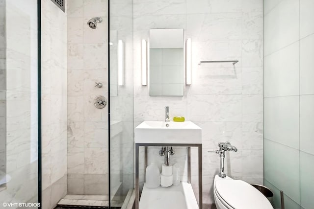 bathroom featuring toilet, tile walls, and tiled shower