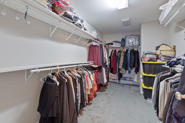 walk in closet featuring light carpet