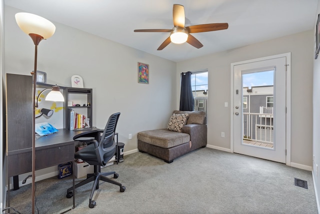 carpeted office space with ceiling fan