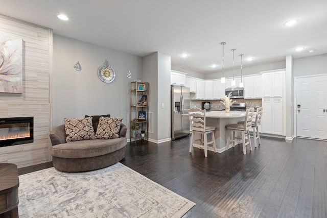 living room featuring dark hardwood / wood-style flooring and a fireplace