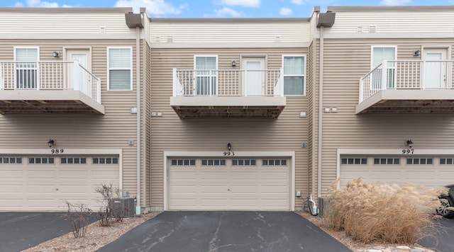 exterior space with central AC unit and a garage