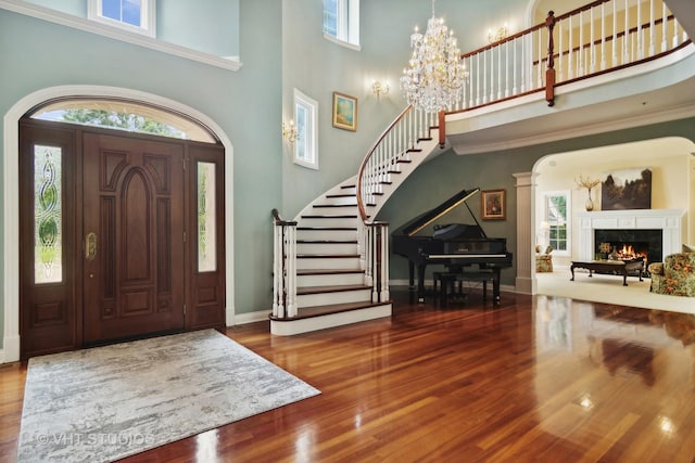 foyer with hardwood / wood-style flooring, a high ceiling, and a chandelier