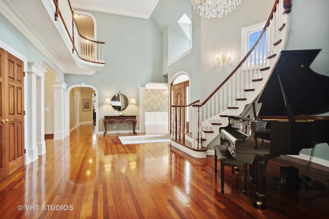 foyer with hardwood / wood-style flooring, a high ceiling, and decorative columns