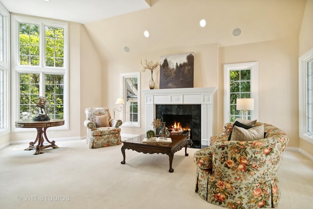 living area with lofted ceiling, light colored carpet, and a premium fireplace