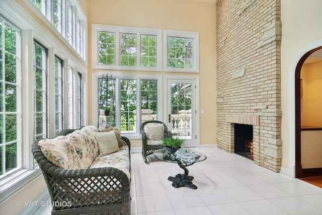 sunroom featuring a healthy amount of sunlight and a fireplace