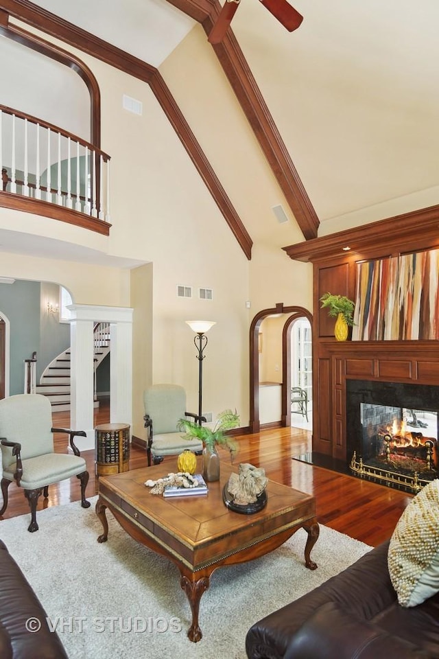 living room with high vaulted ceiling, ceiling fan, and hardwood / wood-style flooring