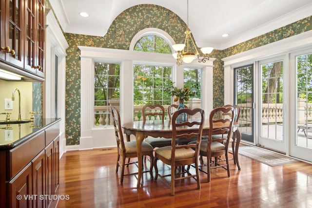 dining space featuring dark wood-type flooring, an inviting chandelier, a wealth of natural light, and sink