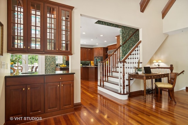 bar featuring dark hardwood / wood-style flooring, decorative backsplash, sink, oven, and beam ceiling