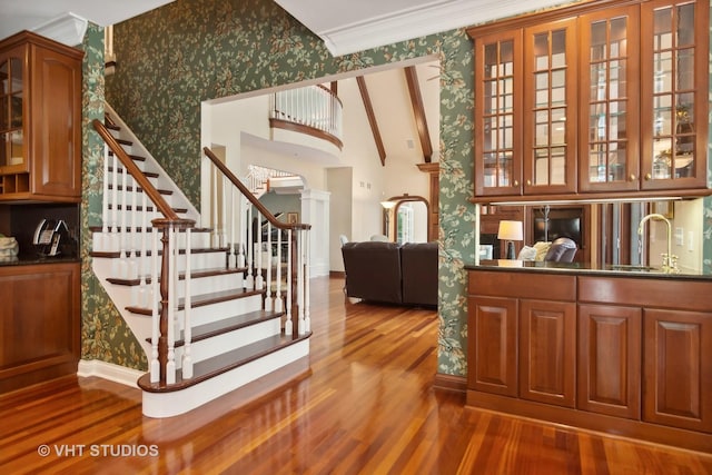 staircase featuring sink, ornamental molding, and hardwood / wood-style floors