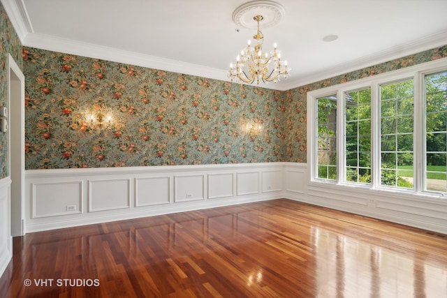 unfurnished dining area with crown molding, wood-type flooring, and a notable chandelier