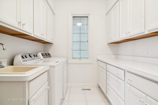 laundry area with cabinets, independent washer and dryer, and light tile patterned flooring