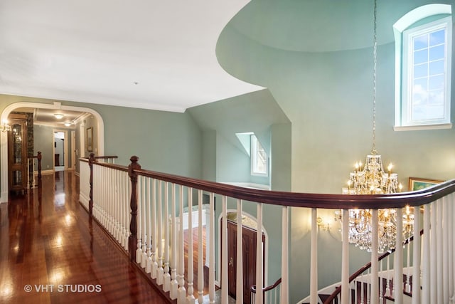 corridor featuring dark wood-type flooring and a notable chandelier