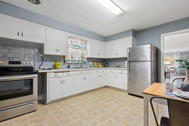 kitchen with appliances with stainless steel finishes, backsplash, and white cabinetry