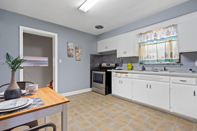 kitchen with white cabinets, tasteful backsplash, stainless steel range with electric cooktop, and sink