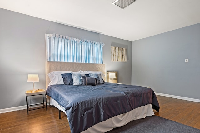 bedroom with dark hardwood / wood-style floors