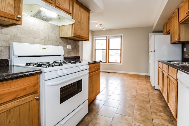 kitchen with decorative backsplash, light tile patterned floors, and white appliances