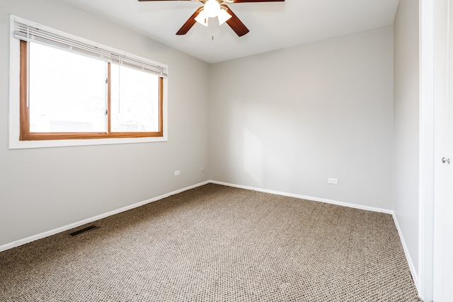 carpeted spare room featuring ceiling fan