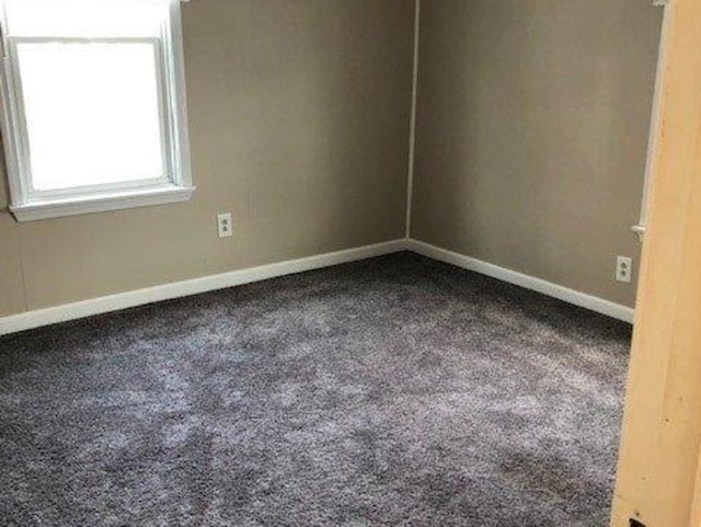 empty room with baseboards and carpet