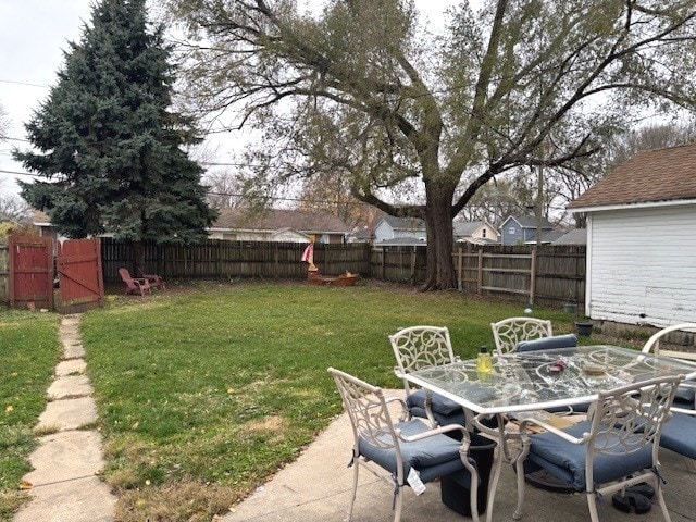 view of yard featuring a patio, outdoor dining area, and a fenced backyard