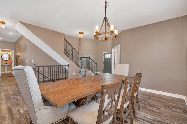 dining space with hardwood / wood-style floors and an inviting chandelier