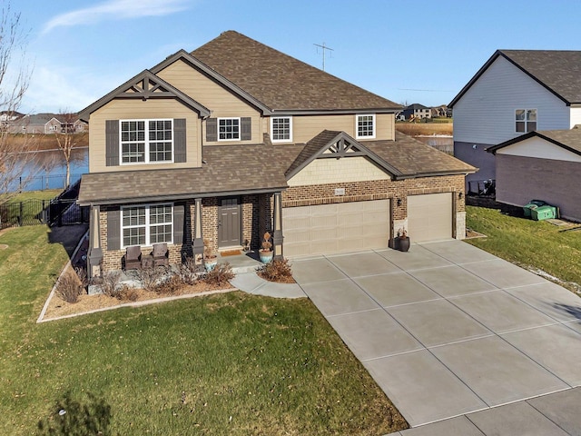 craftsman inspired home featuring a water view, a front yard, and a garage