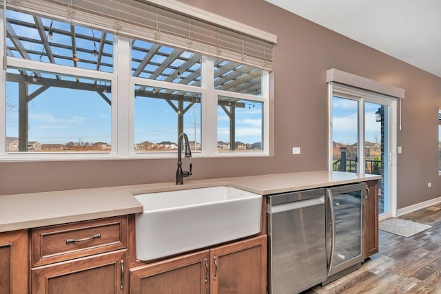 kitchen featuring hardwood / wood-style floors, sink, and beverage cooler