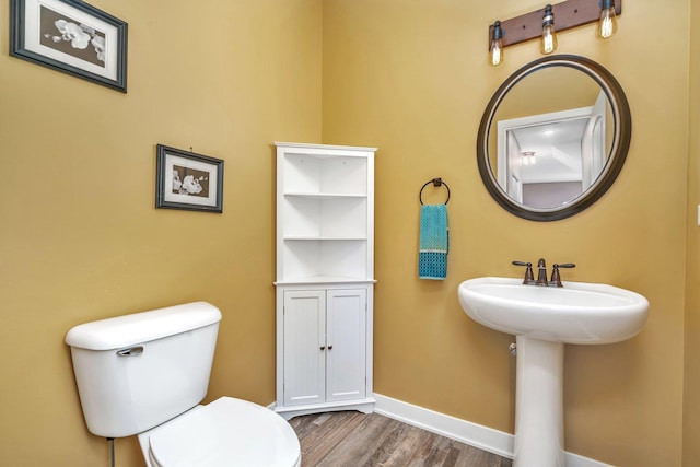 bathroom featuring hardwood / wood-style flooring, toilet, and sink