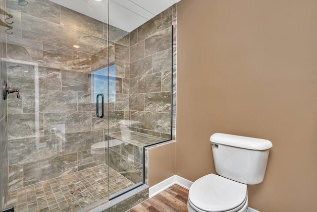 bathroom with hardwood / wood-style floors, toilet, and walk in shower