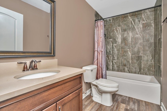 full bathroom with shower / bath combo with shower curtain, hardwood / wood-style floors, vanity, and toilet