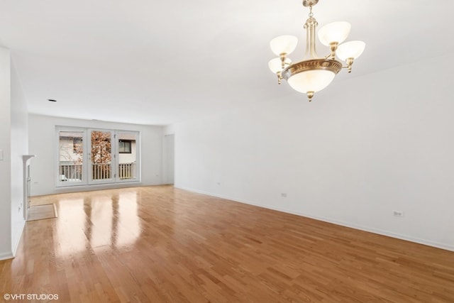 unfurnished living room featuring hardwood / wood-style flooring and a notable chandelier