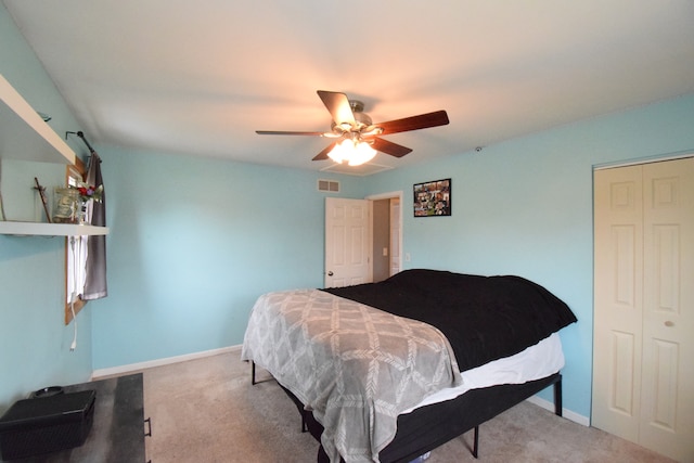 carpeted bedroom with ceiling fan and a closet