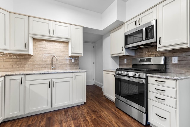 kitchen featuring white cabinets, light stone counters, sink, and stainless steel appliances