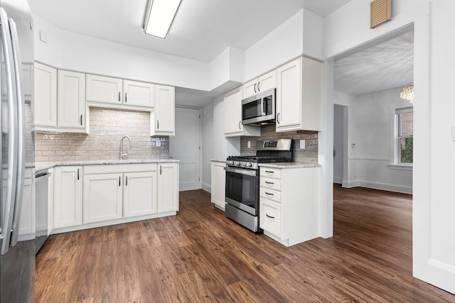 kitchen with light stone countertops, sink, white cabinets, and appliances with stainless steel finishes