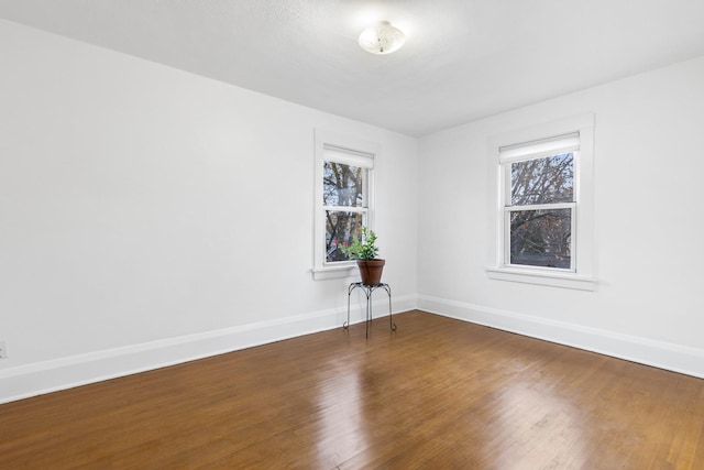 spare room with a wealth of natural light and dark hardwood / wood-style floors