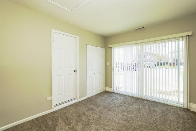 unfurnished bedroom featuring carpet flooring and multiple windows