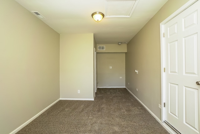 spare room featuring dark colored carpet