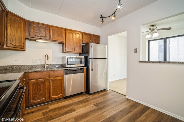 kitchen with dark hardwood / wood-style flooring, stainless steel appliances, ceiling fan, and sink