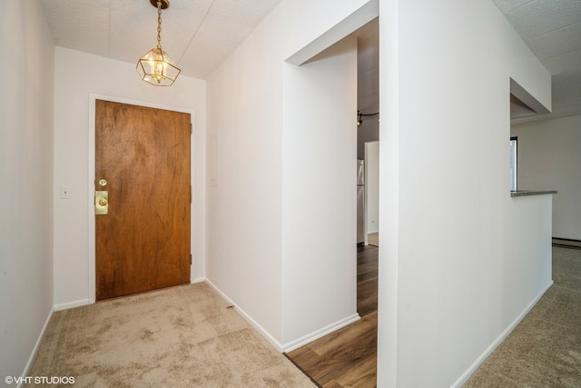 entrance foyer with a textured ceiling, light carpet, and an inviting chandelier