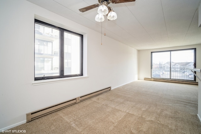 carpeted empty room featuring a wealth of natural light, ceiling fan, a baseboard radiator, and a textured ceiling