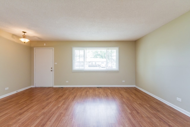 spare room featuring light hardwood / wood-style flooring and a textured ceiling