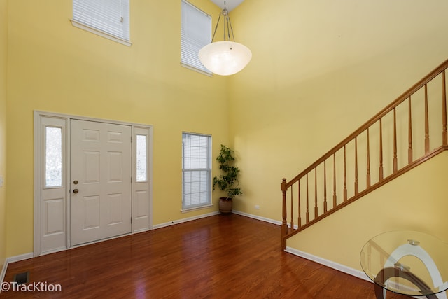 foyer with wood-type flooring and a high ceiling