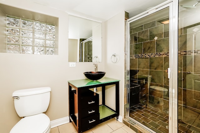 bathroom featuring tile patterned flooring, vanity, a shower with shower door, and toilet