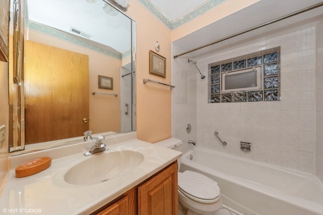 full bathroom featuring vanity, tiled shower / bath, and toilet